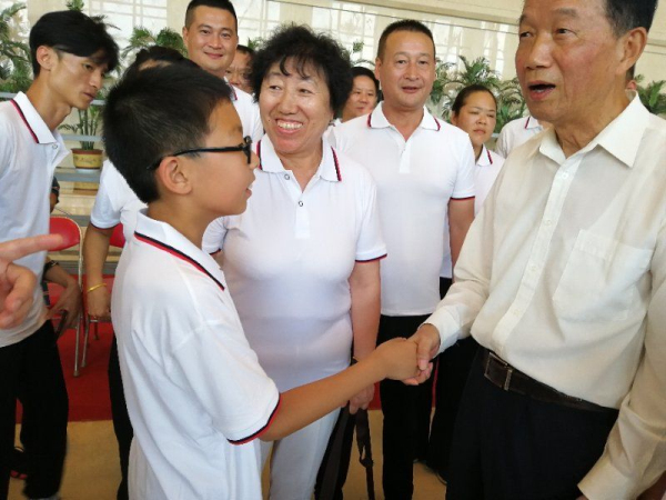 賈春旺理事長(zhǎng)同石樹曾的外孫握手_編輯
