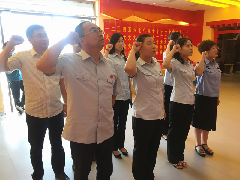大洼法院干警面對(duì)黨旗進(jìn)行重溫入黨誓詞活動(dòng)。
