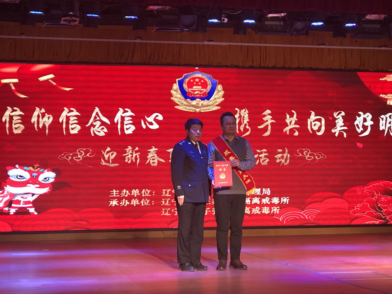 省司法廳副廳長(zhǎng)椰永濤（左）為宋曉頒發(fā)聘書，佩戴戒毒公益大使綬帶