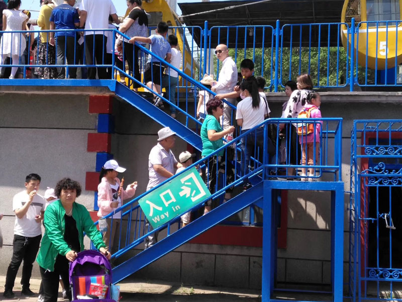 每年六一，陽陽（二樓緩步臺背書包女孩）都能在公園玩?zhèn)€痛快