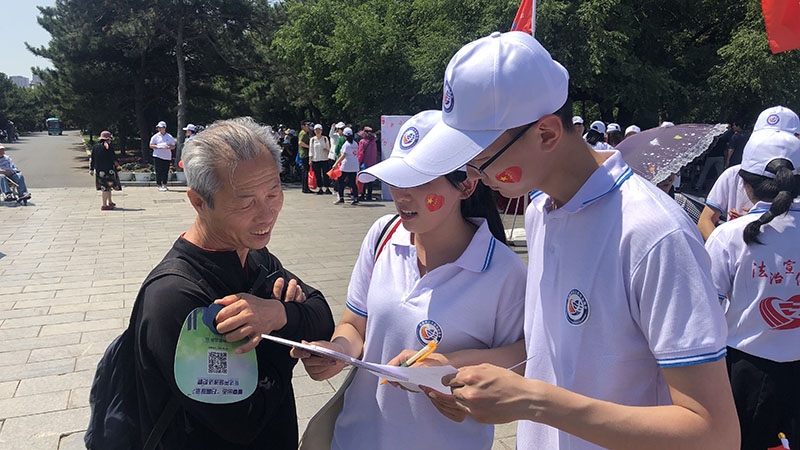 志愿者向市民發(fā)放調(diào)查問(wèn)卷