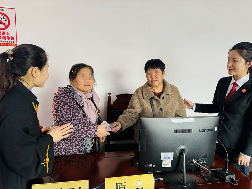 在楊光（左一）和張秋媛（右一）見(jiàn)證下，雙方履行調(diào)解協(xié)議約定（需打碼）