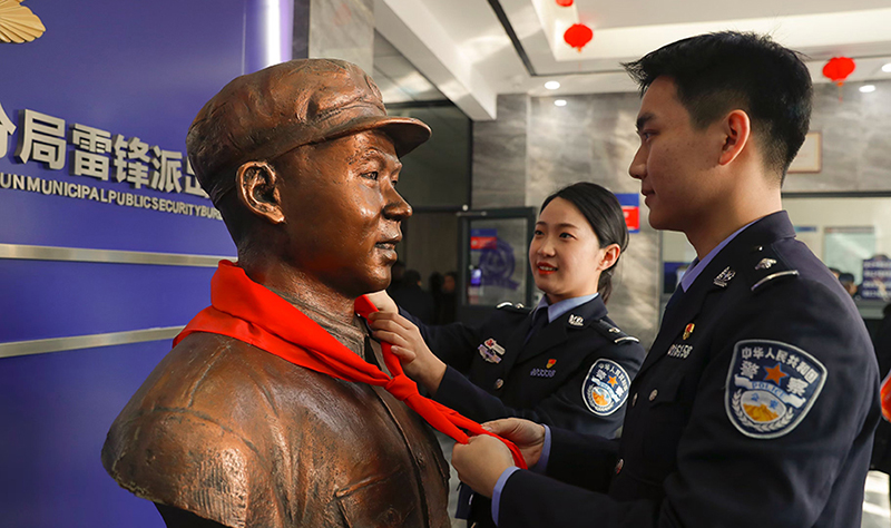 2024年3月5日，撫順市公安局望花分局雷鋒派出所民警白靜（右）和長沙市公安局雷鋒派出所民警韓政霖（左）共同為雷鋒塑像整理紅領(lǐng)巾。