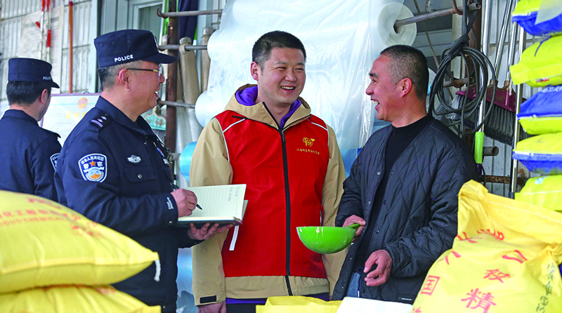 二題圖：在一家農(nóng)藥化肥經(jīng)銷店,民警向店主提示,農(nóng)忙時電信詐騙多,要注意防范電信詐騙,同時不要經(jīng)營偽劣農(nóng)藥化肥。