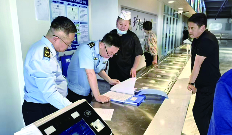 執(zhí)法人員在學校食堂后廚檢查食材進貨渠道