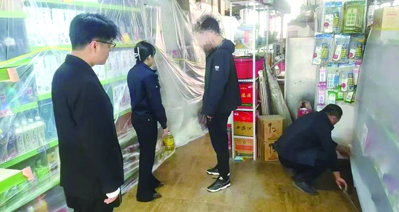 二圖，法院干警正在幫助一樓商戶粘貼防塵塑料布