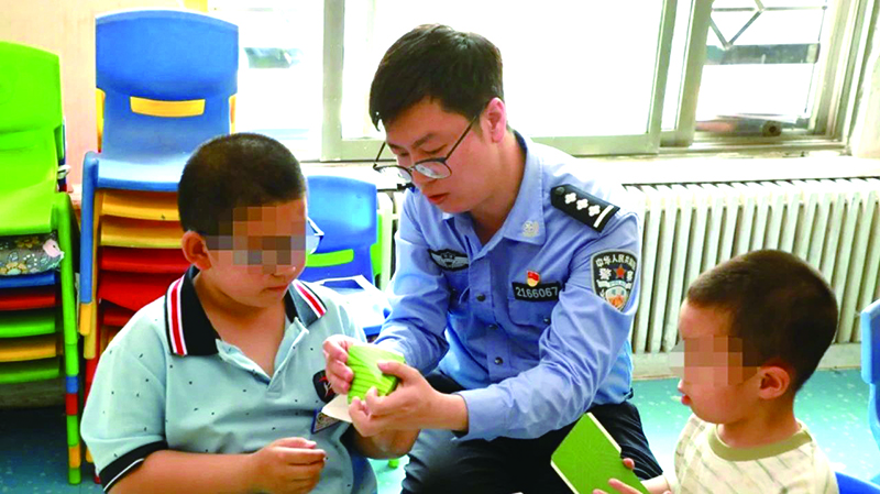 二題圖，民警在營(yíng)口市金石自閉癥兒童幼兒園指導(dǎo)孩子制作粽子折紙